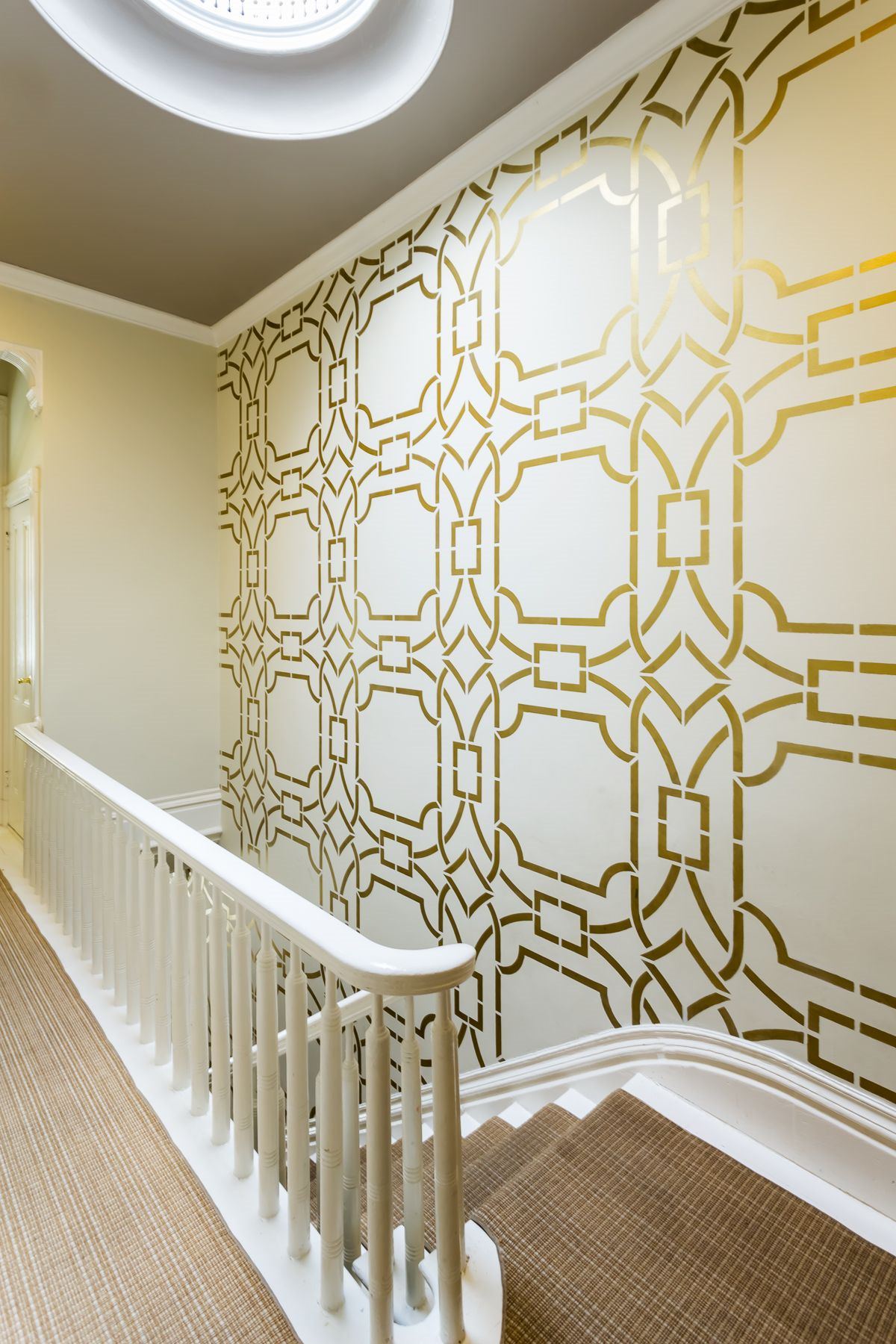 راه پله ای که از ترکیب کاغذ دیواری متالیک و رنگ کرم در آن استفاده شده است